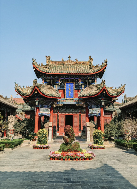 A serene courtyard of a historic Buddhist temple in China, featuring traditional architecture and lush greenery.